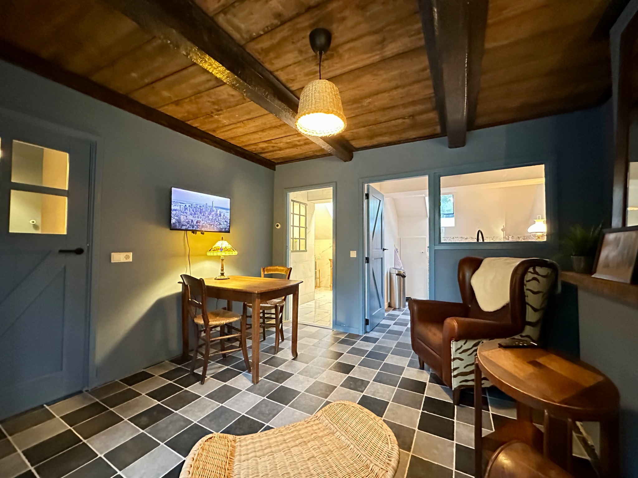 De zitkamer van De Swarte Swaen met eettafel, fauteuils en houten balken.